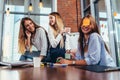 Two girls laughing at their friend with a sticky note on her face. Group of female students relaxing having fun in Royalty Free Stock Photo