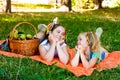 Two Girls Lie On Orange Picnic Blanket With Picnic Basket Royalty Free Stock Photo