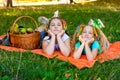 Two Girls Lie On Orange Picnic Blanket With Picnic Basket In The Park Royalty Free Stock Photo