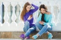 Two girls listening to music on their smartphones. Royalty Free Stock Photo