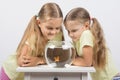 Two girls looking down at a goldfish in an aquarium Royalty Free Stock Photo