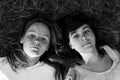 Two girls lying on the grass. Black and white portrait. Royalty Free Stock Photo