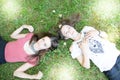 Two girls lying on a green grass in flower meadow Royalty Free Stock Photo