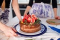 Two girls making a cake on the kitchen. Beautiful cake with cream and decoration of grapefruit and pomegranate. Royalty Free Stock Photo