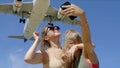 Two Girls Making Selfie With A Plane Royalty Free Stock Photo