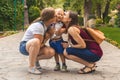 Two girls mom kiss their capricious little boy child in the park. Not a traditional family