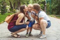 Two girls mom kiss their capricious little boy child in the park. Not a traditional family