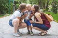 Two girls mom kiss their capricious little boy child in the park. Not a traditional family