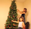 Two girls near Christmas tree Royalty Free Stock Photo