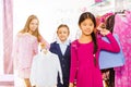 Two girls and one boy hold chosen clothes in store Royalty Free Stock Photo