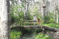 Two girls over a wooden bridge over a stream Royalty Free Stock Photo