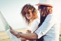 Two girls planning their summer seaside road trip with convertible Royalty Free Stock Photo