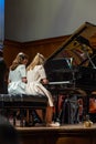 Two girls playing four hands concert.