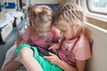 Two girls playing in the second-class tablet in a train