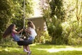 Two Girls Playing Together On Tire Swing In Garden Royalty Free Stock Photo