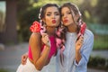 Two girls posing and making duckface with candies heart on stick. Royalty Free Stock Photo