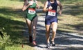 Two girls racing downhill during a chigh school ross country race Royalty Free Stock Photo