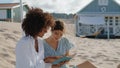 Two girls reading book on summer beach picnic. Happy lesbian couple talking Royalty Free Stock Photo