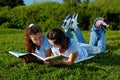 Two girls reading books outside in a park Royalty Free Stock Photo