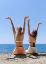 Two girls resting at the sea, rear view Royalty Free Stock Photo