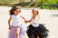 Two girls running with fantacy dresses in park. Royalty Free Stock Photo