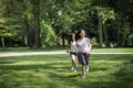 Two girls running in the park on a summer day.