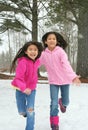 Two girls running through the snow