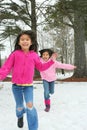 Two girls running through the snow