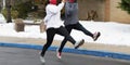 Two girls running track speed drills in a parking lot because of snow