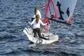 Two Girls Sailing small sailboat with long red hair viewed closeup from behind