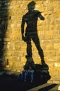 Two girls seated in the shadow of Michelangelo`s David, Florence,Italy.under the