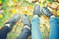 Two girls shoes on autumn leaves, top view, toned photo