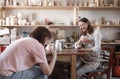 two girls shoot a video blog in an art workshop while making wooden toys. Royalty Free Stock Photo