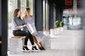 Two girls with shopping sitting on a bench in the Mall Royalty Free Stock Photo