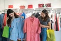 Two girls shopping in the store. Girlfriends choose the best modern clothes in mall Royalty Free Stock Photo