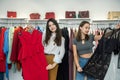 Two girls shopping in the store. Girlfriends choose the best modern clothes in mall Royalty Free Stock Photo