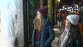 Two girls on a shopping trip in New York walk along shop windows - NEW YORK, USA - DECEMBER 4, 2018