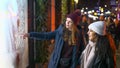 Two girls on a shopping trip in New York walk along shop windows - NEW YORK, USA - DECEMBER 4, 2018