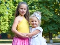 Two girls sister portrait, childhood concept, happy child posing in city park Royalty Free Stock Photo