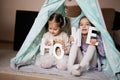 Two girls sisters at wigwam tent with wooden home letters