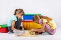 Two girls sit on the floor and collect a toy house Royalty Free Stock Photo