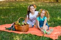 Two Girls Sit On Orange Picnic Blanket With Picnic Basket Royalty Free Stock Photo