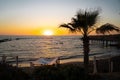 Two girls sit on sup board in the quiet mediterranean sea at sunset in the city of paphos in cyprus. Silhouettes of 2 Royalty Free Stock Photo