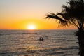 Two girls sit on sup board in the quiet mediterranean sea at sunset in the city of paphos in cyprus. Silhouettes of 2 Royalty Free Stock Photo