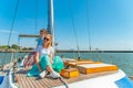 Two girls sit on a yacht on the deck near the mast and look out into the sea. Royalty Free Stock Photo