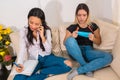 Two girls sitting on the couch talking to customers on the phone