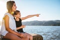 Two girls sitting on dock and pointing Royalty Free Stock Photo