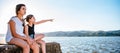 Two girls sitting on dock and pointing Royalty Free Stock Photo