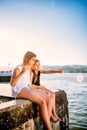 Two girls sitting on dock and pointing Royalty Free Stock Photo