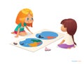 Two girls sitting on floor and trying to assemble world map puzzle.